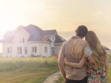 rear view of couple looking at new home